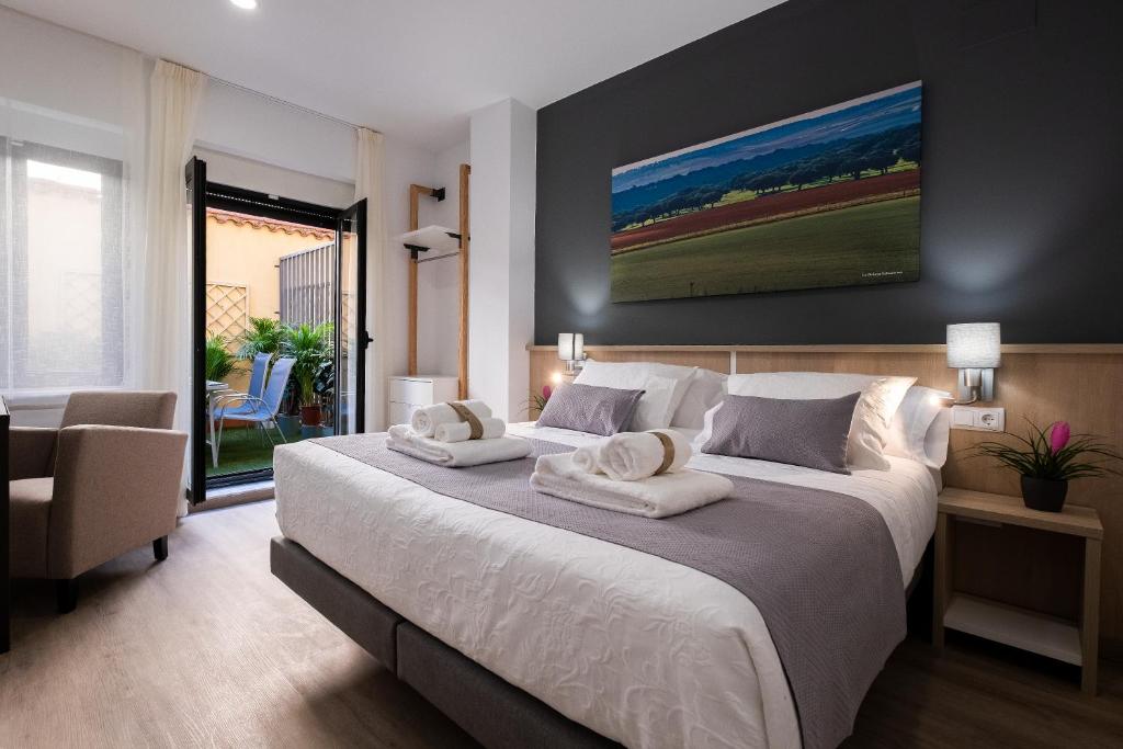 萨拉曼卡Luxor Torre del Clavero Apartments的一间卧室配有一张大床和两条毛巾