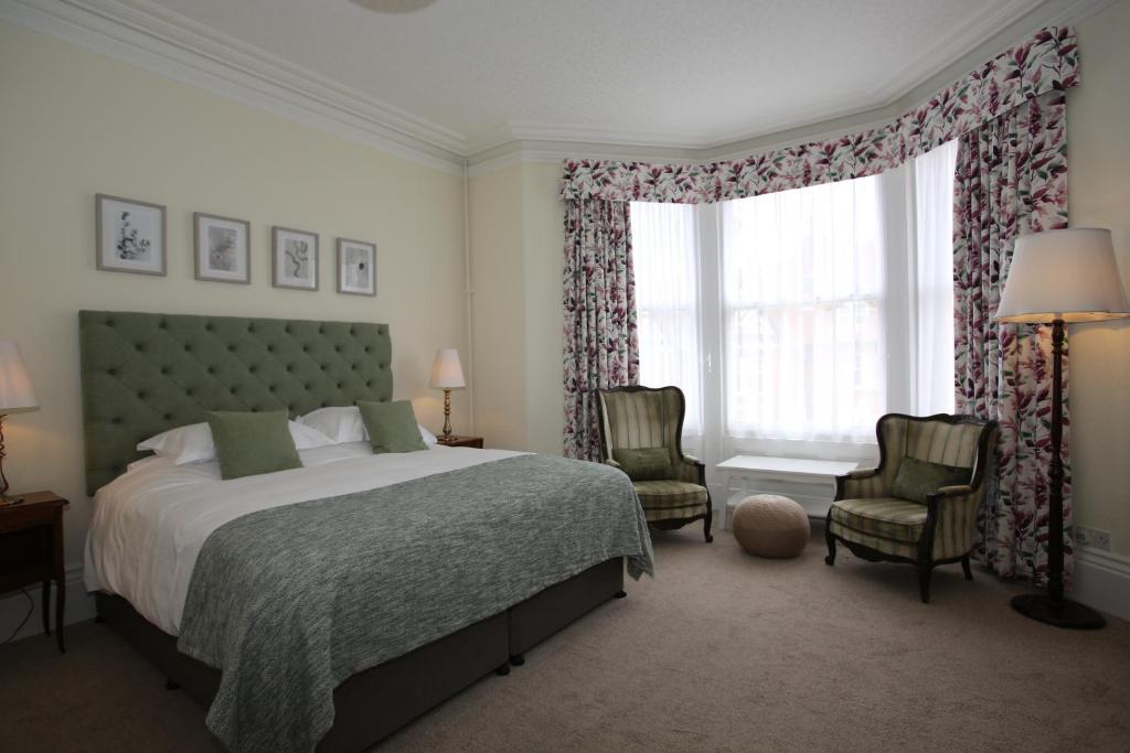 斯卡伯勒科迪莉亚酒店的一间卧室配有一张床、两把椅子和一个窗户