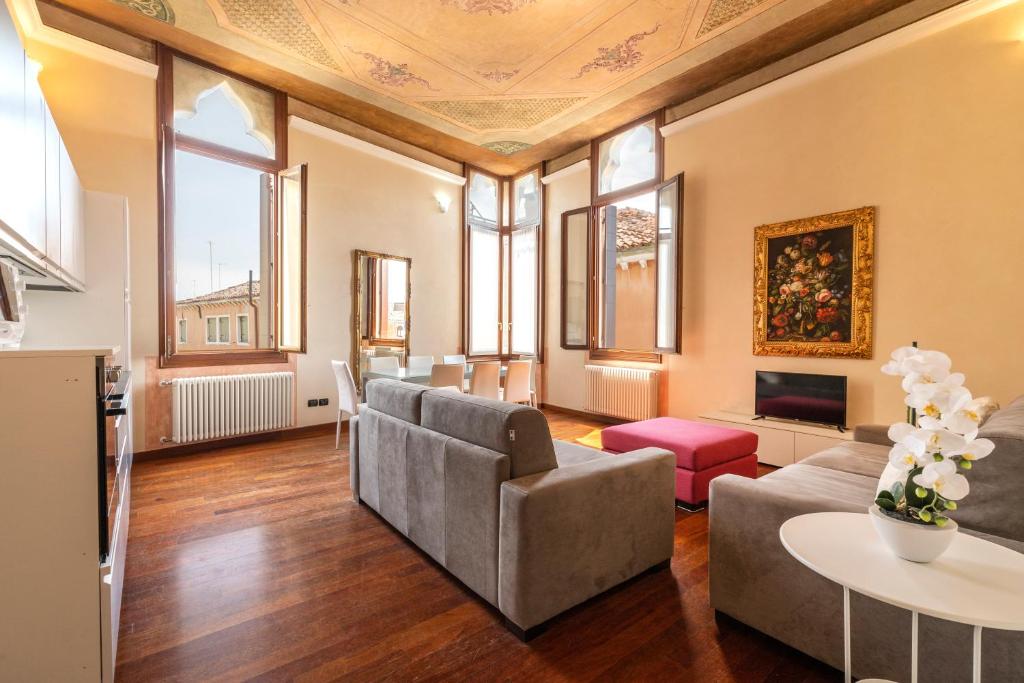 威尼斯莫罗西尼总督宫公寓的客厅配有沙发和桌子