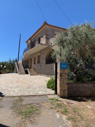 斯陶帕ΤΟ ΠΕΤΡΙΝΟ / THE PETRINO APARTMENTS的前面有蓝色标志的大砖房子