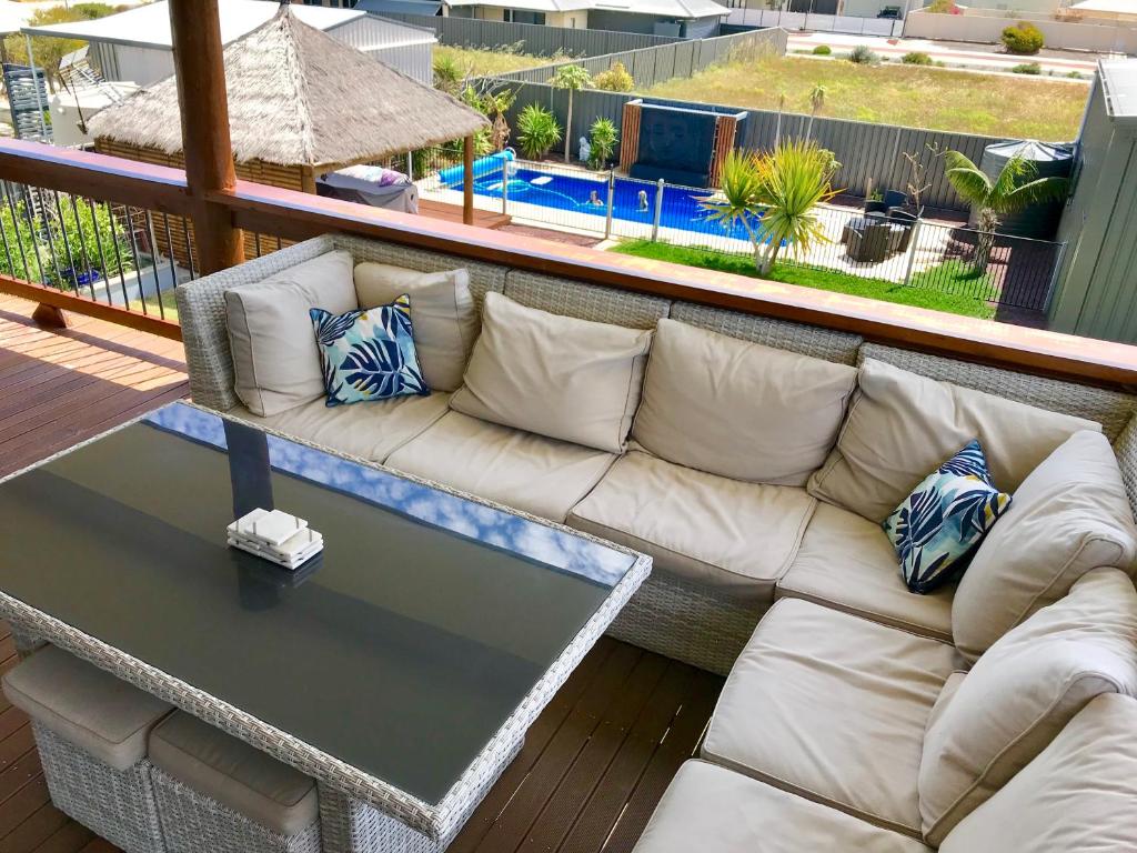 朱里恩湾Coastal Paradise Jurien Bay的一张坐在甲板上的白色沙发,配有桌子