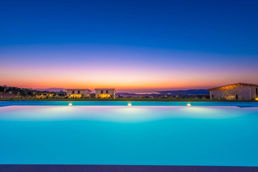 卡兰兹拉Mint Retreat Suites的享有游泳池的景色,背景是日落