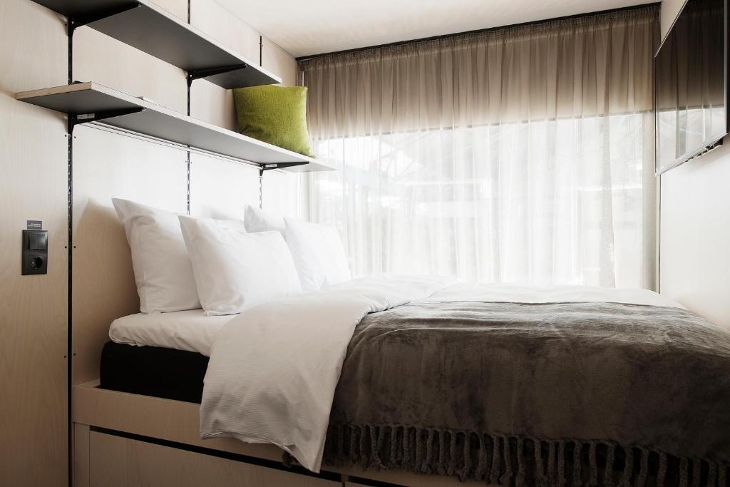 塔林Hektor Container Hotel的卧室配有带白色枕头的床和窗户。