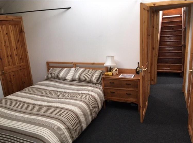 蒙特罗斯Montrose Watertower的一间卧室配有一张床和一张带台灯的桌子