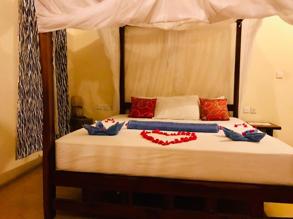 拉穆莫斯艾菲妮酒店的一间卧室配有一张带红色枕头的天蓬床