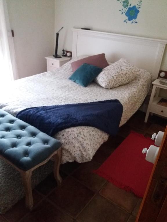 GuarazocaCasa Bermeja的一间卧室配有一张床和一个蓝色的搁脚凳