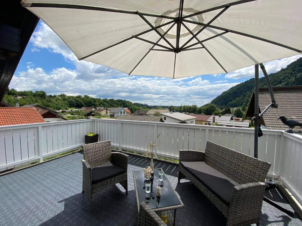克拉尼Apartment Kranj - huge terrace, free P, WI - FI, AC的天井配有遮阳伞、2把椅子和1张桌子