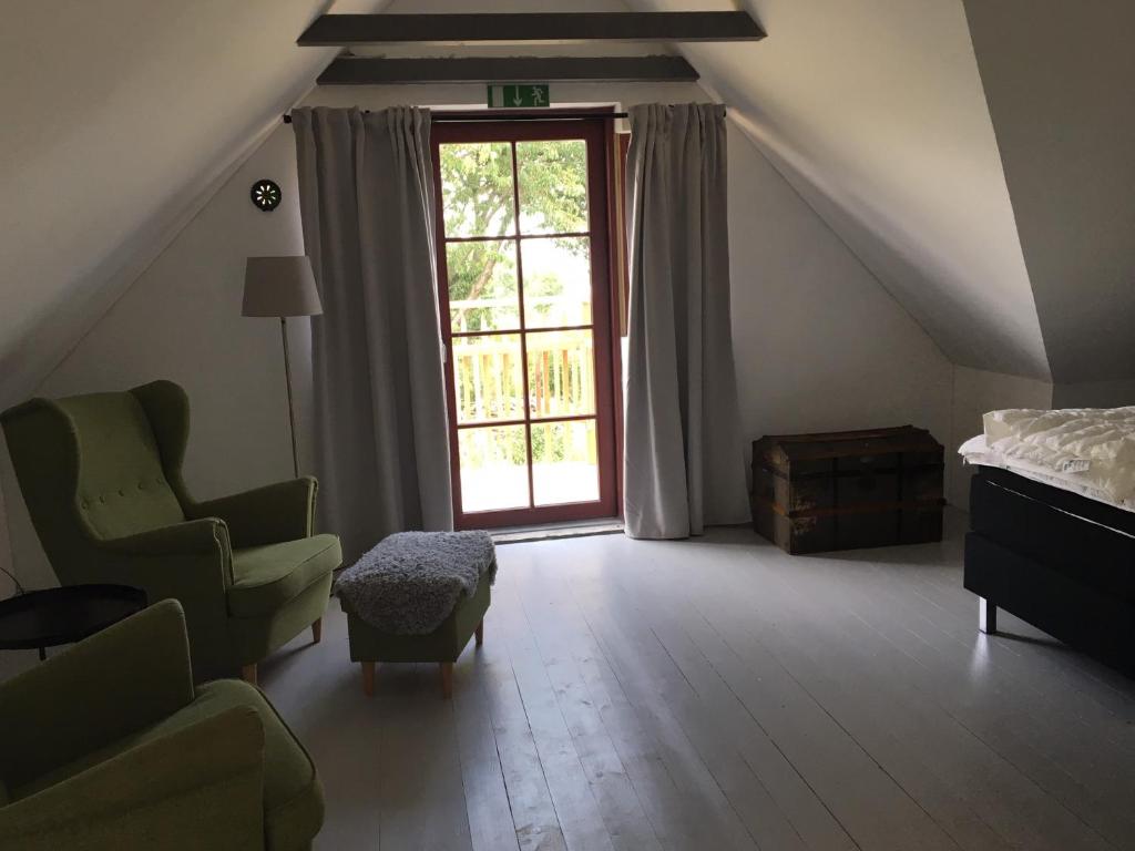 奇维克Annagården Österlen的卧室配有床、椅子和窗户。