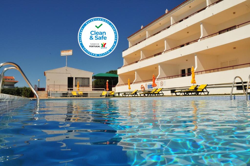 奎特里拉索尔加维公寓式酒店的游泳池位于酒店前,配有干净的安全标志
