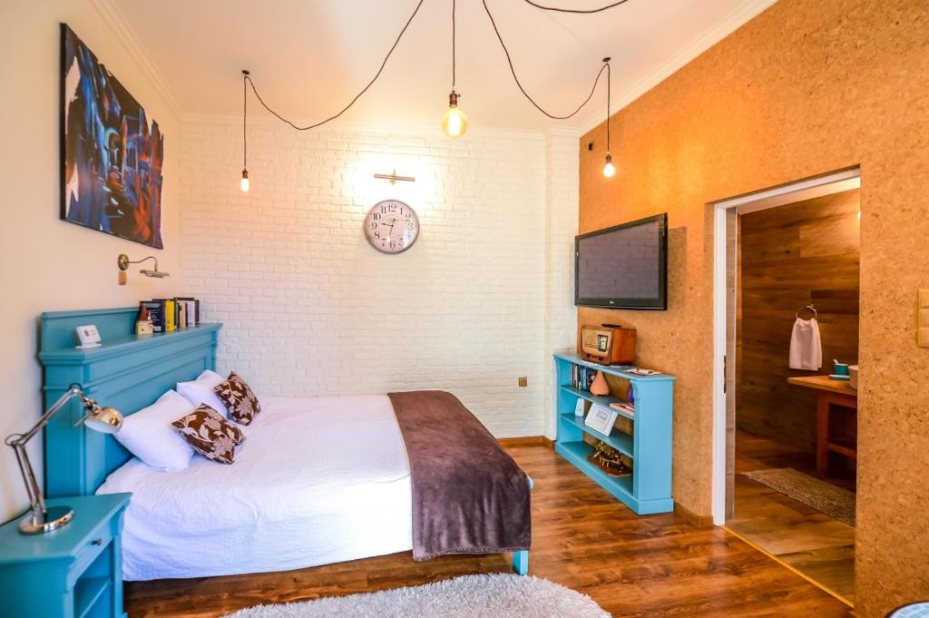 锡吉什瓦拉ATRIUM 24 Suite的一间卧室配有蓝色的床和电视