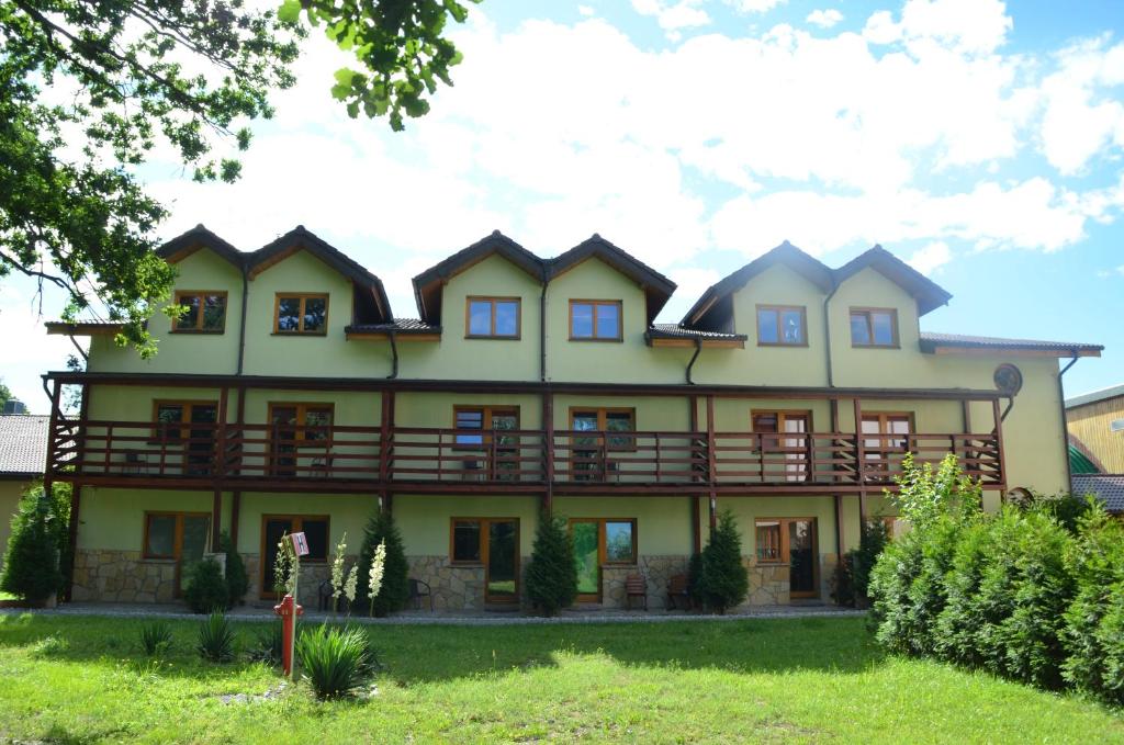 Chrząstowice特尼斯酒店的一座黄色的大房子,有围着门廊
