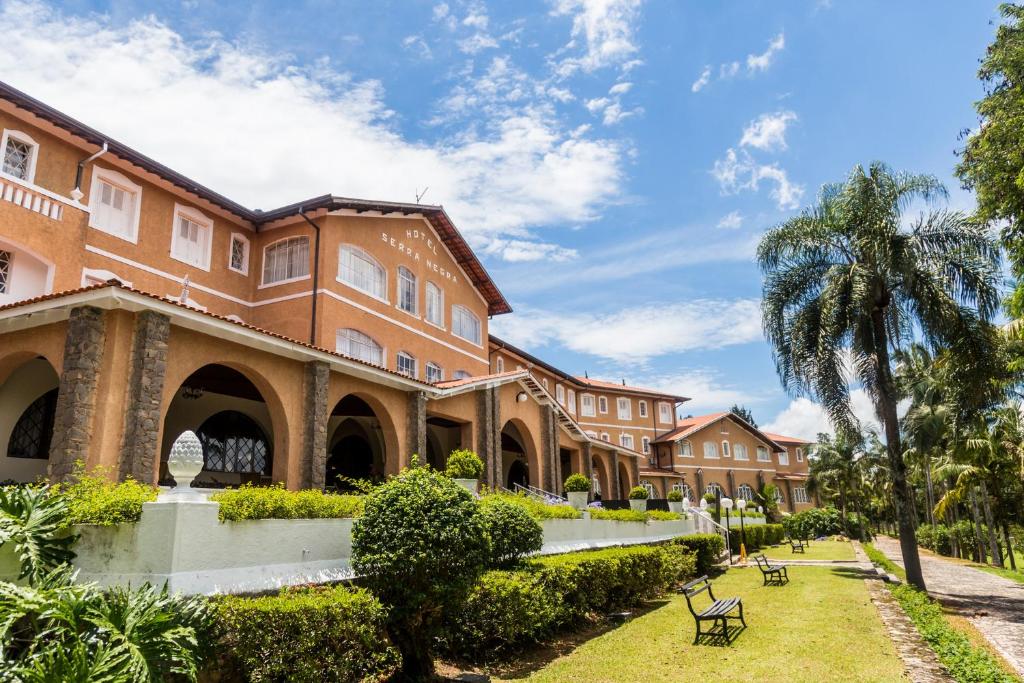 塞拉内格拉Grand Resort Serra Negra的前面有棕榈树的建筑