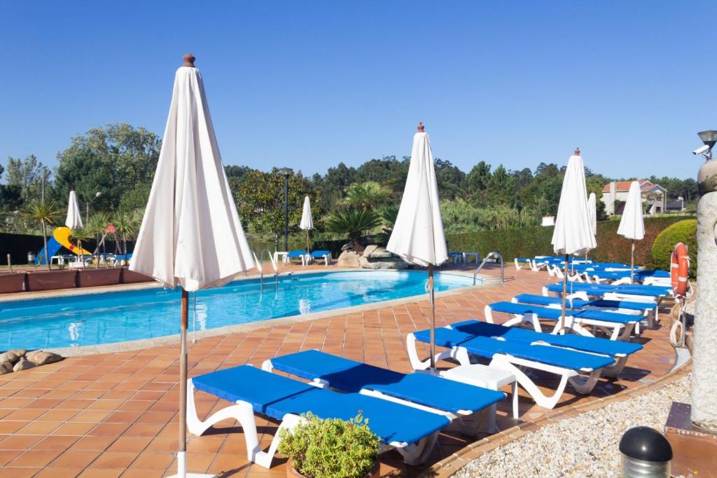 波多诺伏卡内拉斯酒店的一个带蓝色和白色躺椅和遮阳伞的游泳池