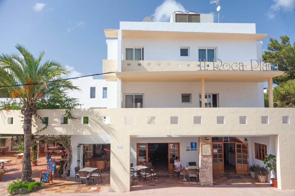 埃斯普霍斯Hotel Roca Plana的白色的建筑,标有朗索卡饮料的标志