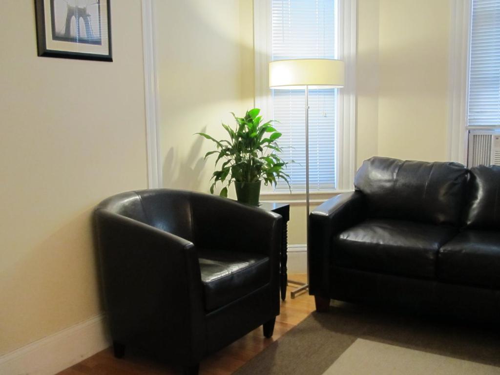 萨默维尔Bowers House Bed and Breakfast的客厅配有黑色真皮沙发和椅子