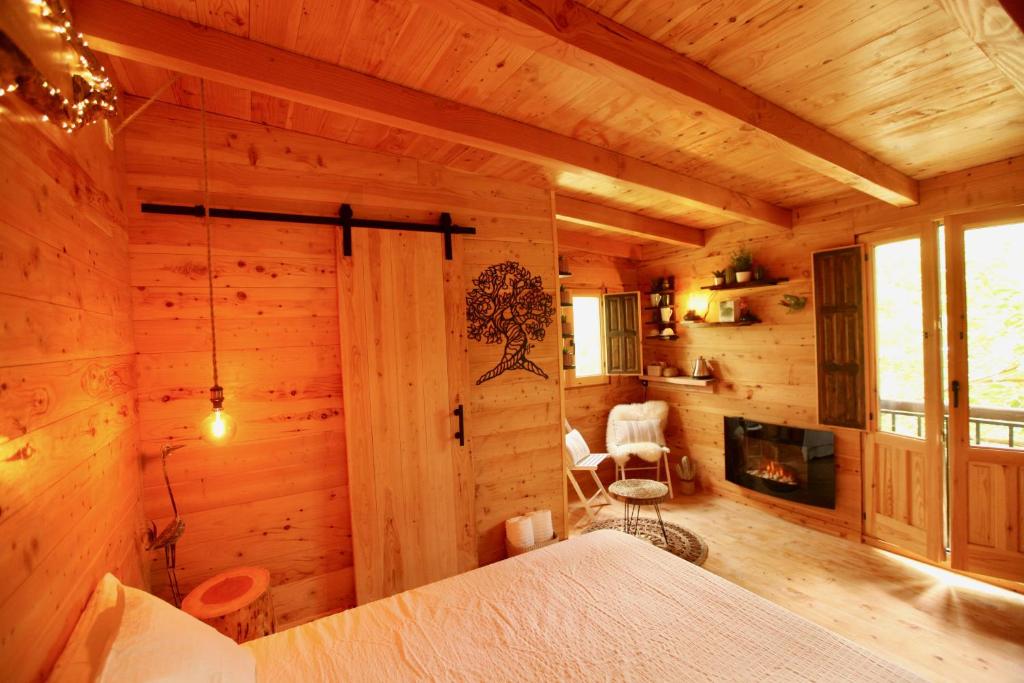 布拉内斯NatureTreeHouse Casa sobre los árboles的小木屋的卧室配有一张床和一个壁炉