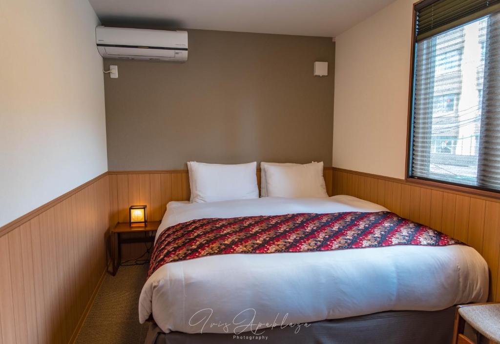 京都Hotel Sou Kyoto Gion的一间卧室设有一张大床和窗户