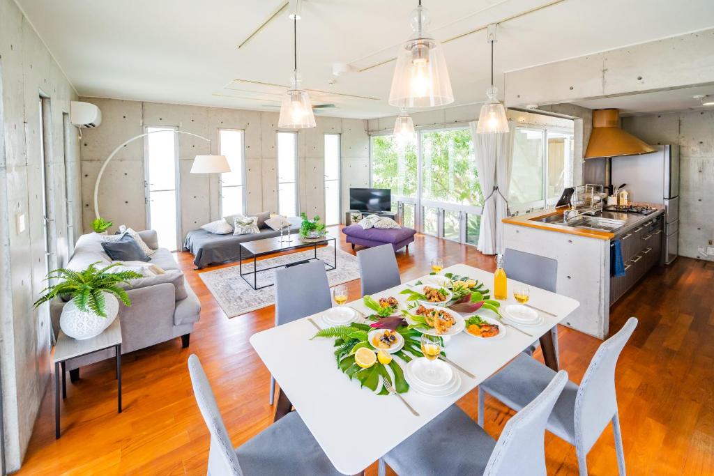 宇流麻EM Tree House的厨房以及带白色桌椅的起居室。