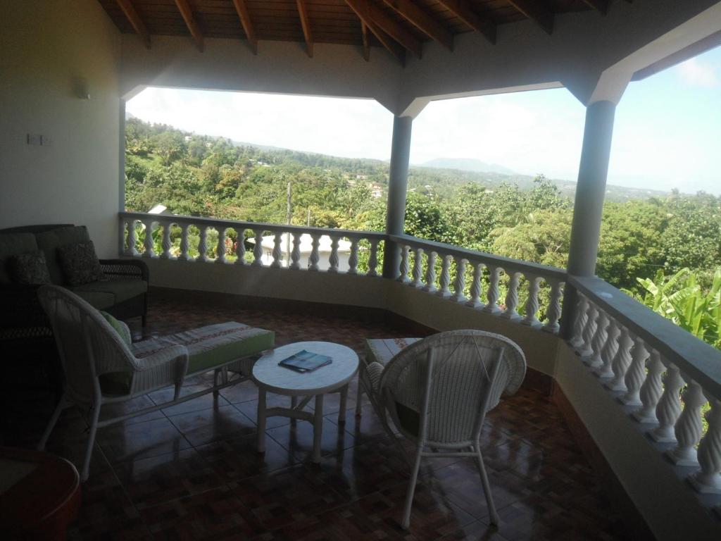 Marigot多米尼加克拉斯克国际酒店的阳台配有沙发、椅子和桌子