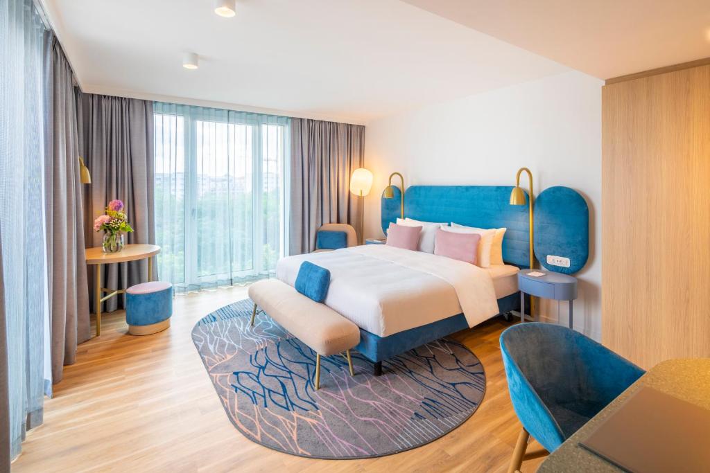 莱比锡Capri by Fraser Leipzig的一间卧室配有一张带蓝色家具的大床