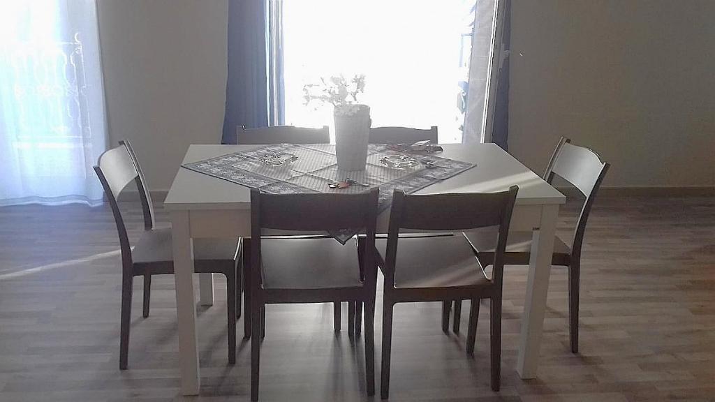 泰尔米尼伊梅雷塞Case marino的白色的餐桌,椅子和花瓶