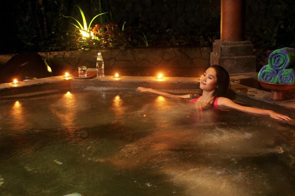 沙拉迪加拉热斯阿斯里度假酒店及Spa中心的女人晚上在热水浴缸中游泳