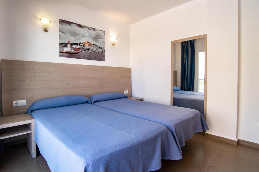 普拉亚登博萨维斯塔马二号公寓酒店的一间卧室设有蓝色的床和窗户。