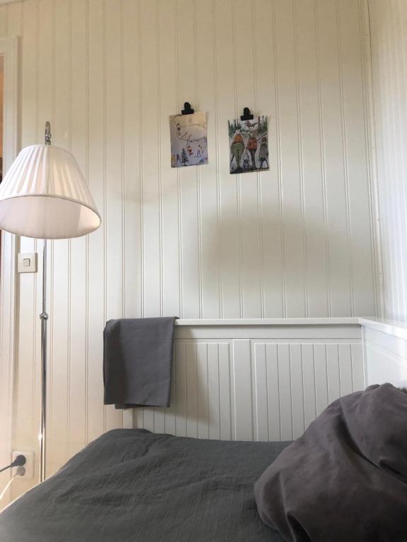 莫拉Mormors vrå的一间卧室配有一张床和一盏灯,墙上挂着照片