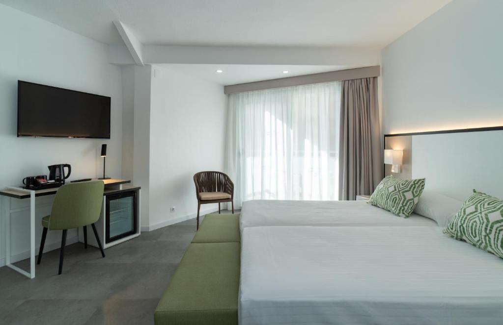 贝尼多姆梅德普拉亚摄政酒店的酒店客房配有一张床、一张书桌和一台电视。