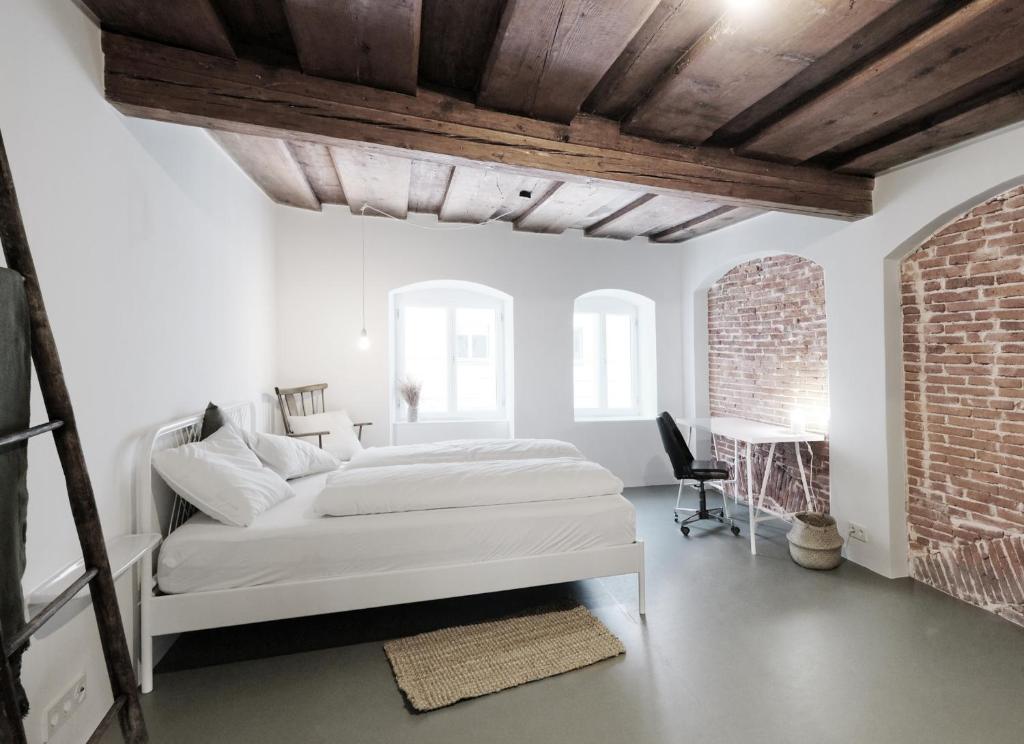 林茨CHARMANTES APARTMENT im Herzen von Linz的白色卧室配有床和书桌