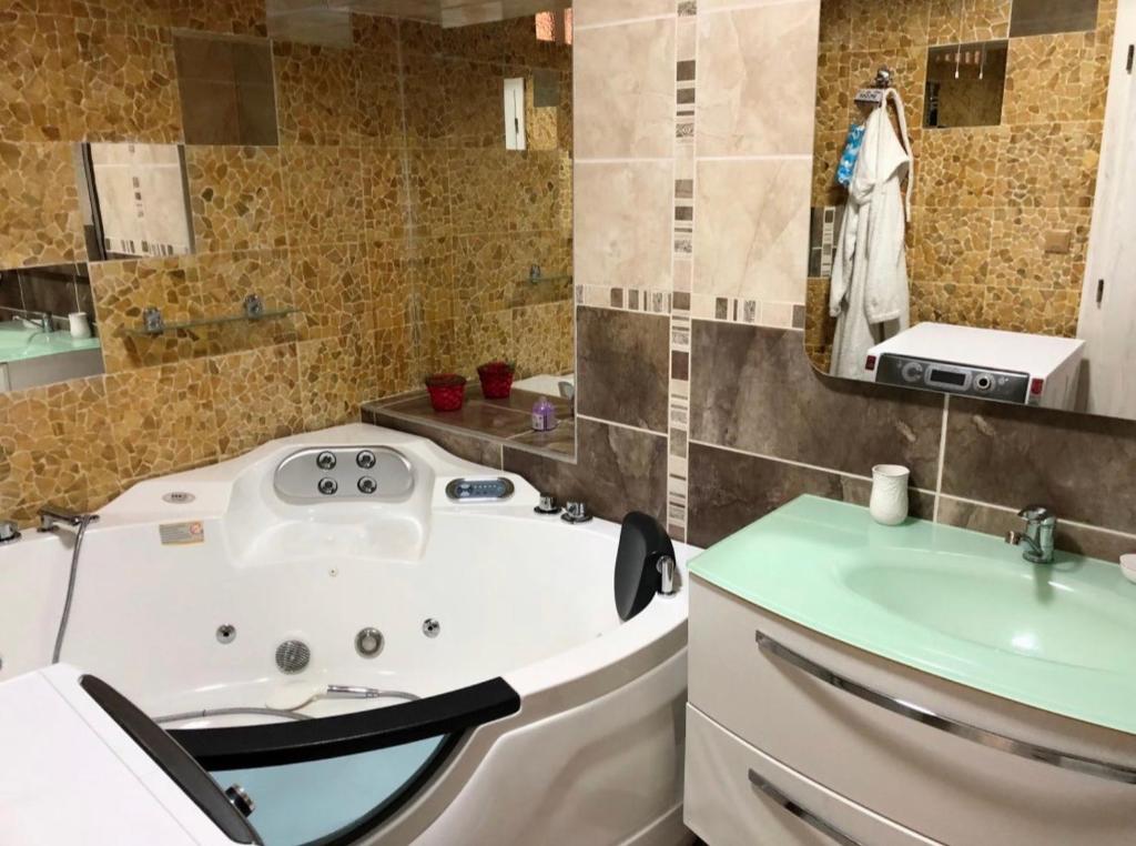 弗格拉什Bella Casa Apartments的带浴缸和盥洗盆的浴室