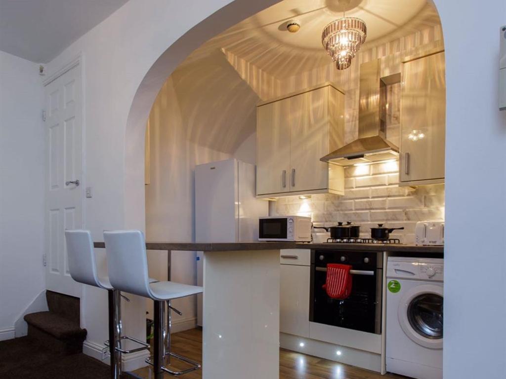 利兹沙夫茨伯里公寓的厨房配有带椅子和炉灶的柜台