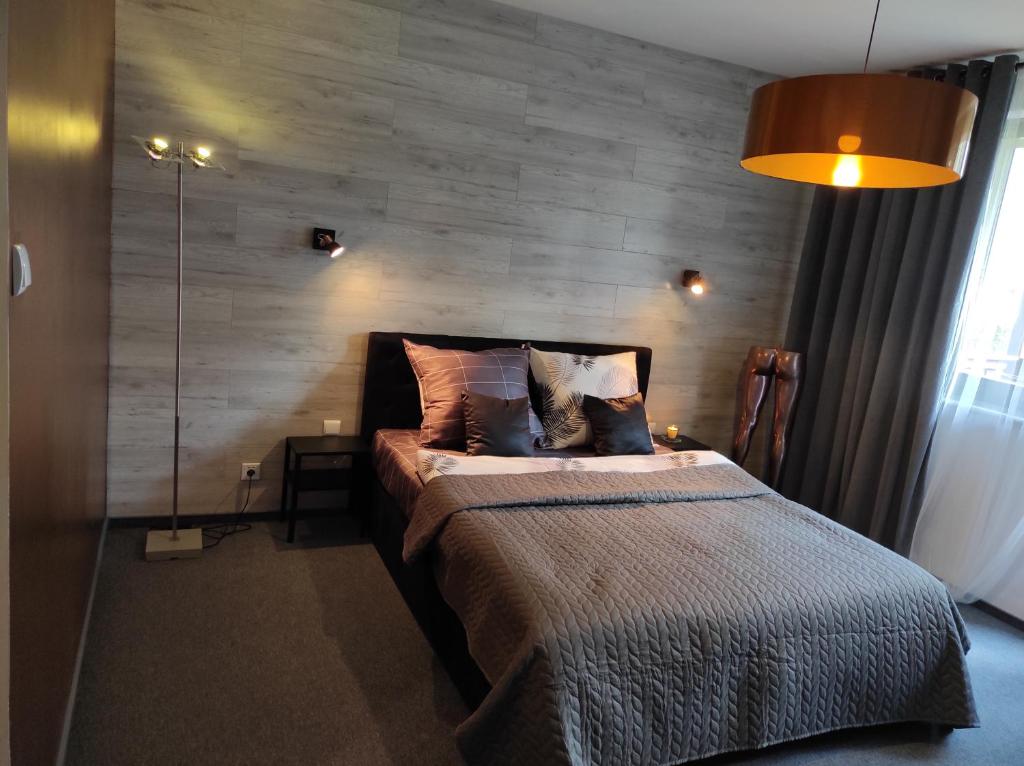 格但斯克Heliosa Apart Gdańsk Kowale的一间卧室配有一张木墙床