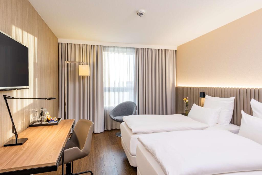 汉堡汉堡阿尔托那NH酒店的酒店客房配有两张床和一张书桌