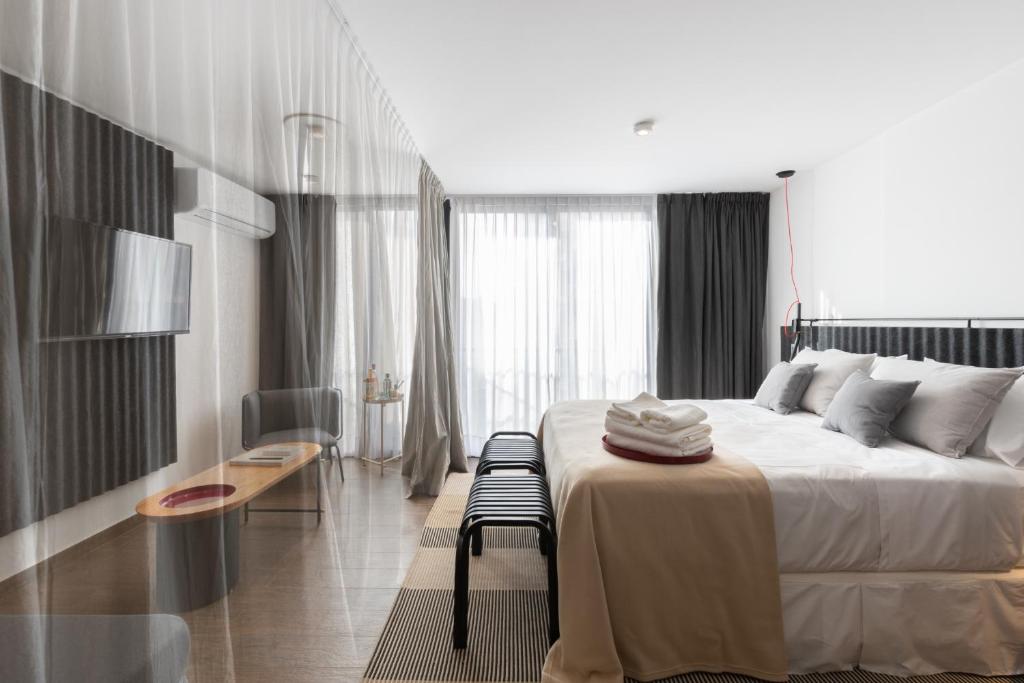 科尔多瓦Stay Suites的一间卧室配有一张大床、一张桌子和一把椅子
