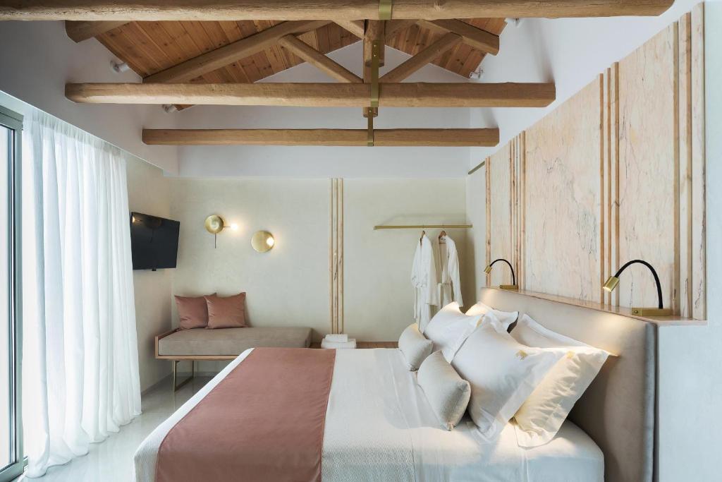 干尼亚Mirabile Luxury Suites的卧室配有一张白色的大床和一张沙发。