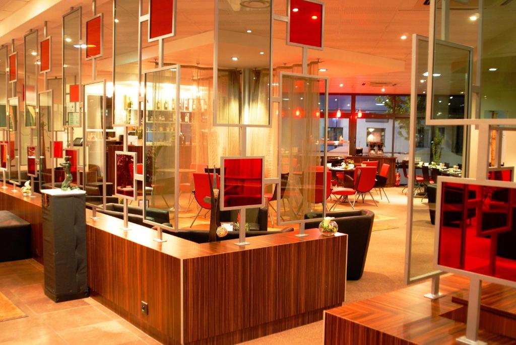特雷拉泽巴特里尔卢瓦尔餐厅及酒店的餐厅设有红色椅子和玻璃墙