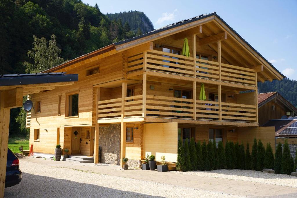 奥伯斯特多夫Leos Alpenchalet - inclusive Sommer Bergbahnticket und E-Auto Ladestation的一座大型木制建筑,其侧面设有阳台