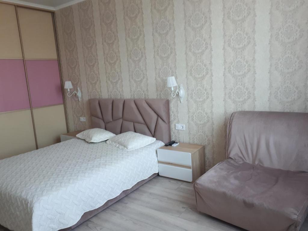 敖德萨Apartments Lutsdorf的一间小卧室,配有一张床和一把椅子