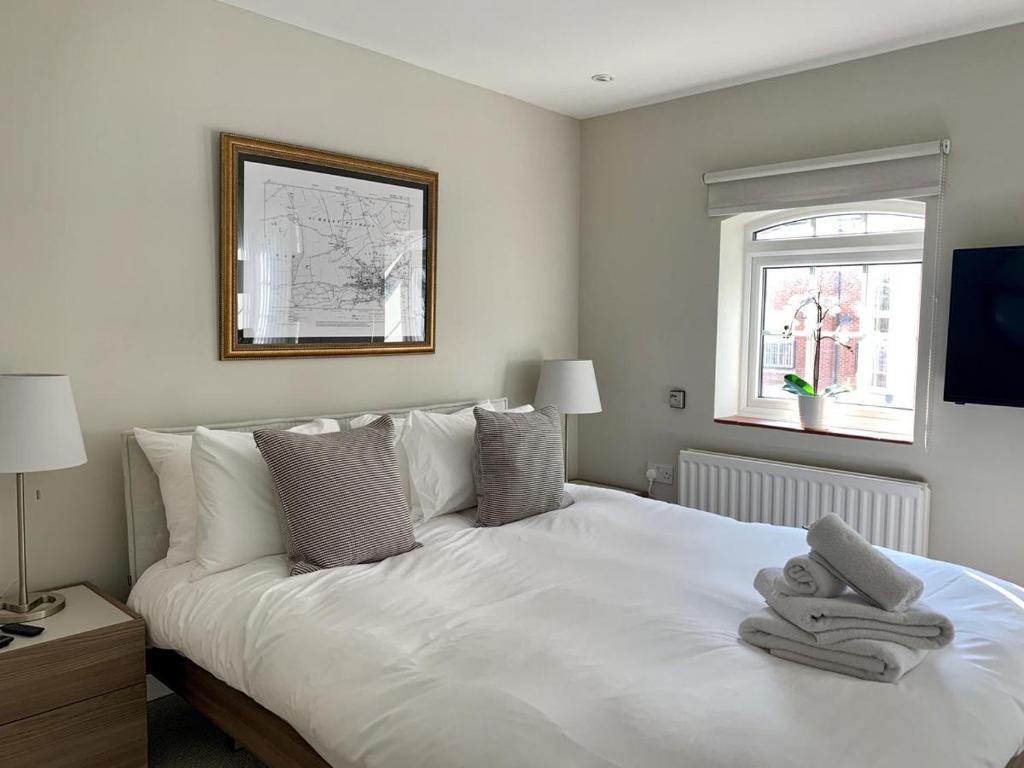 阿宾登Brewery Cottage的卧室配有白色床和毛巾