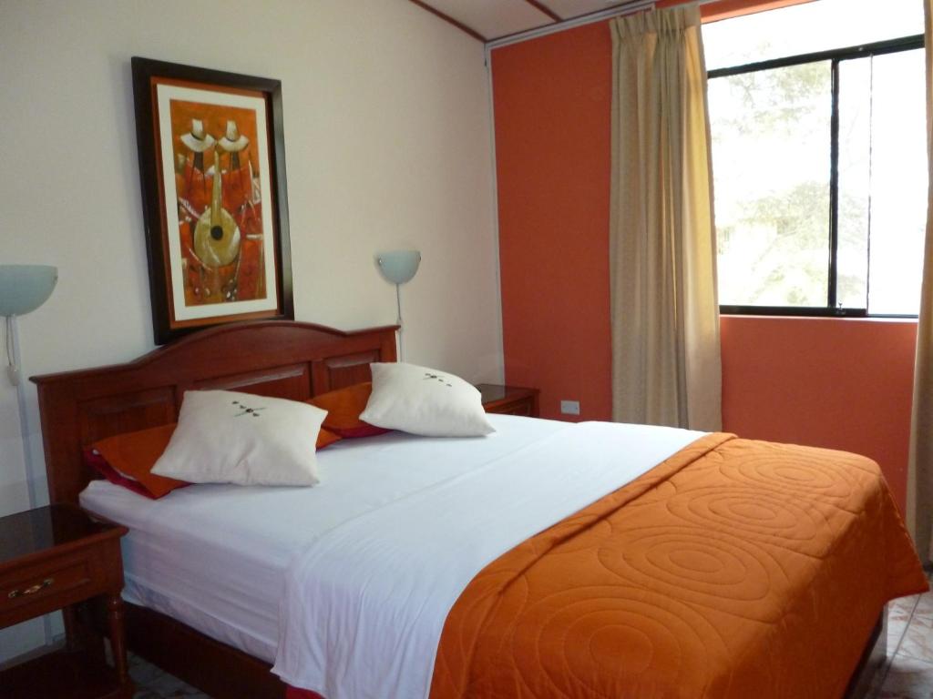 皮乌拉圣何塞酒店的卧室配有一张带白色床单的大床和窗户。