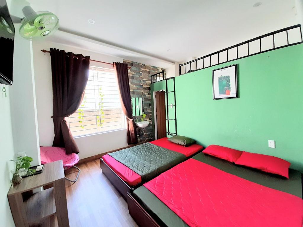 岘港Homestay Xì Trum的一间卧室设有红色的床和绿色的墙壁