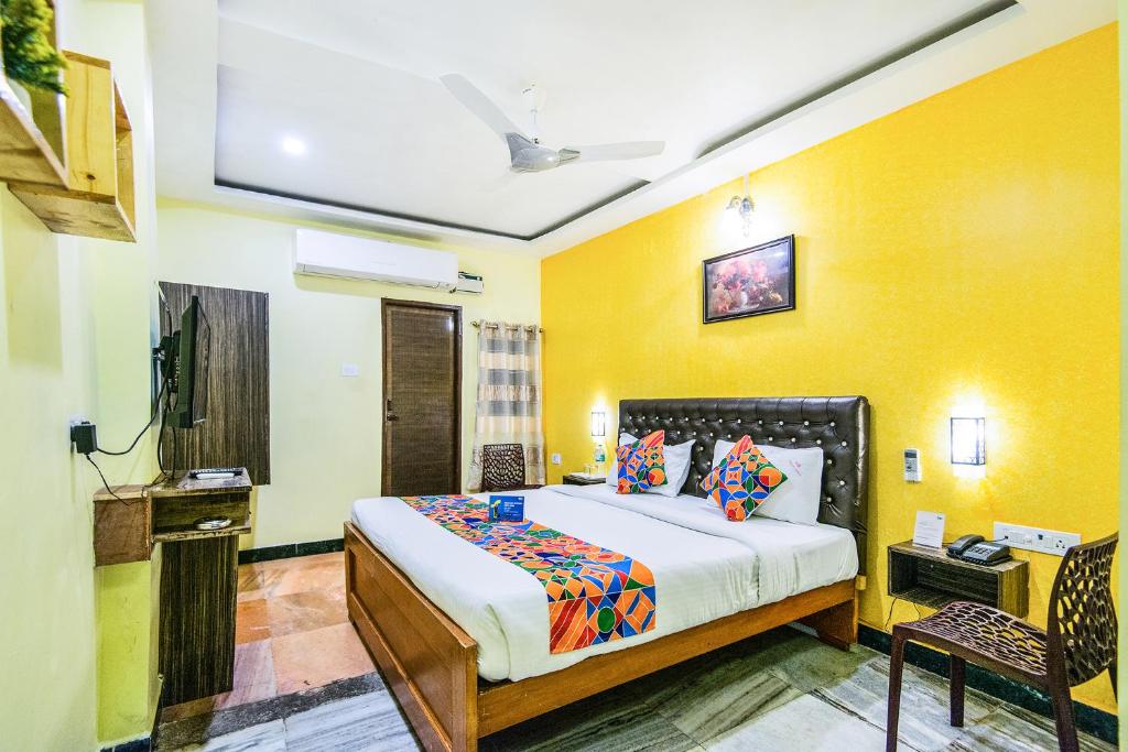 钦奈Royal Palace Marina的一间卧室设有一张床和黄色的墙壁