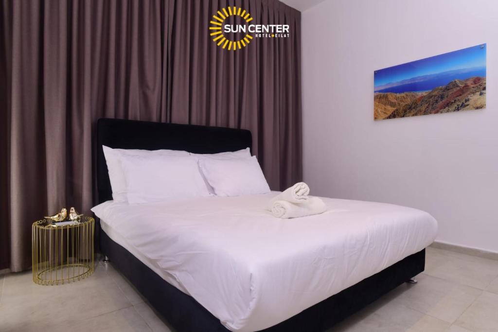 埃拉特Sun Center Eilat的一间卧室配有一张带白色床单的大床