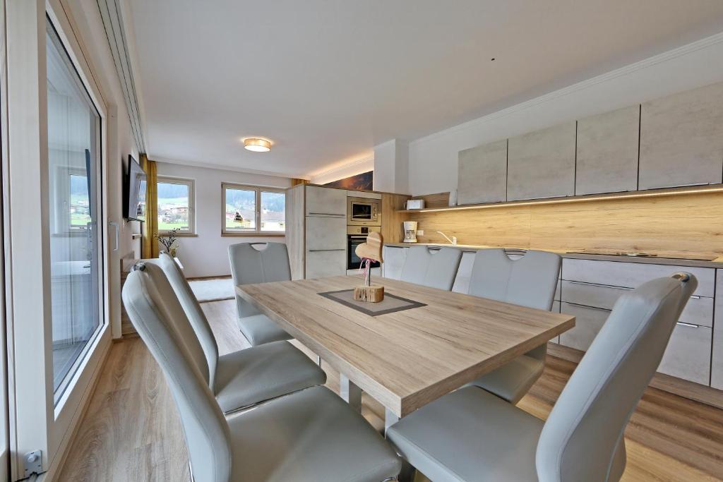 齐勒谷地里德Apartment Jäger的一间带木桌和椅子的用餐室