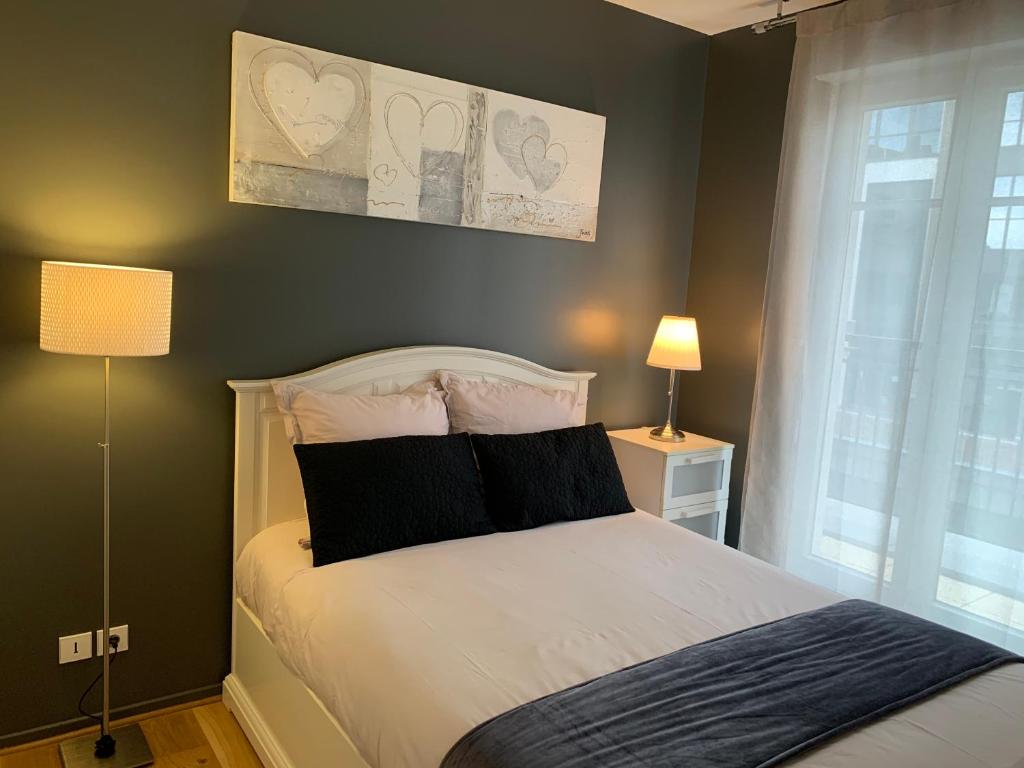 谢西Appartement Disneyland au centre du Val d'Europe的一间卧室配有一张带黑白枕头的床