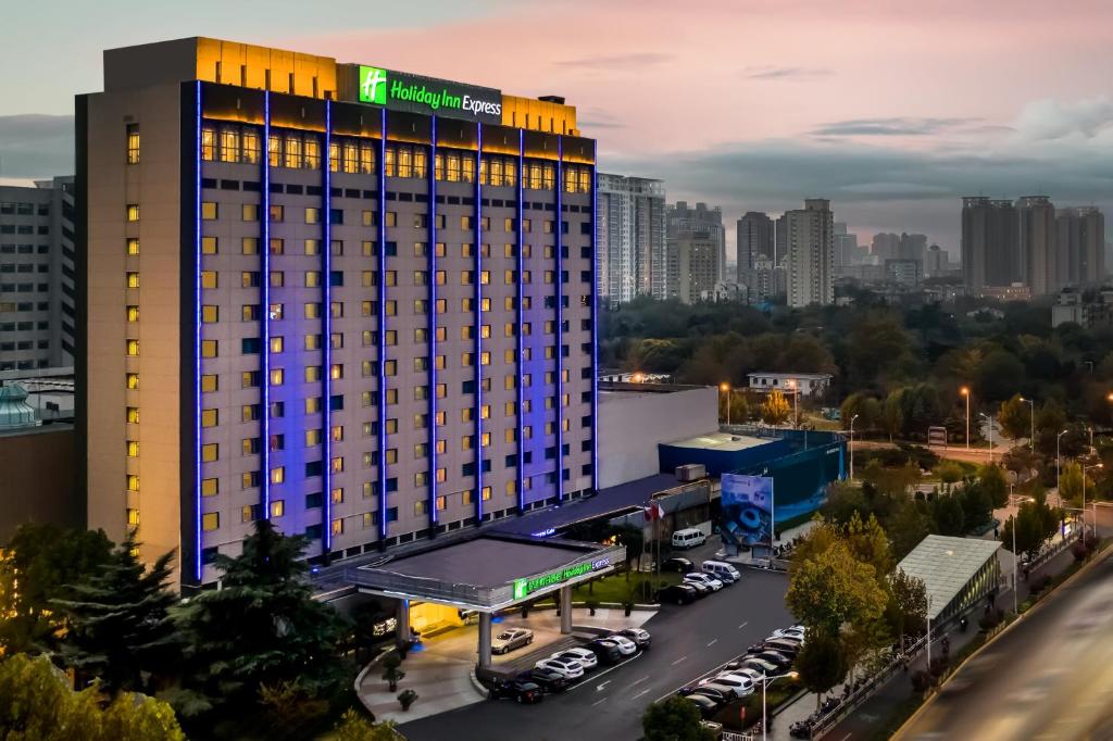 郑州河南中州智选假日酒店的一座酒店大楼,在城市前设有停车场