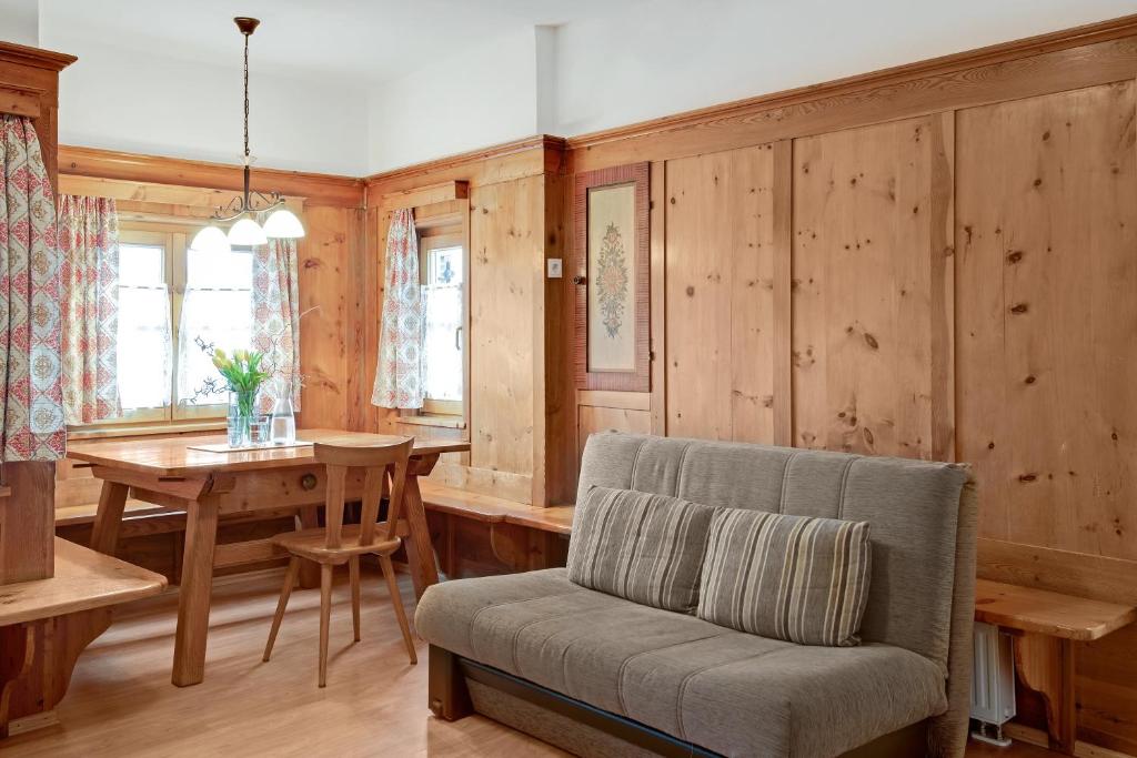 韦尔图尔诺Rafaser - Apartment Rustika的客厅设有木墙、桌子和椅子