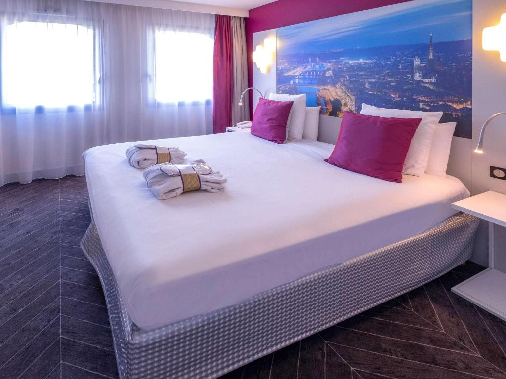 鲁昂Mercure Rouen Centre Champ de Mars的一张大床,位于酒店客房内,配有粉红色枕头