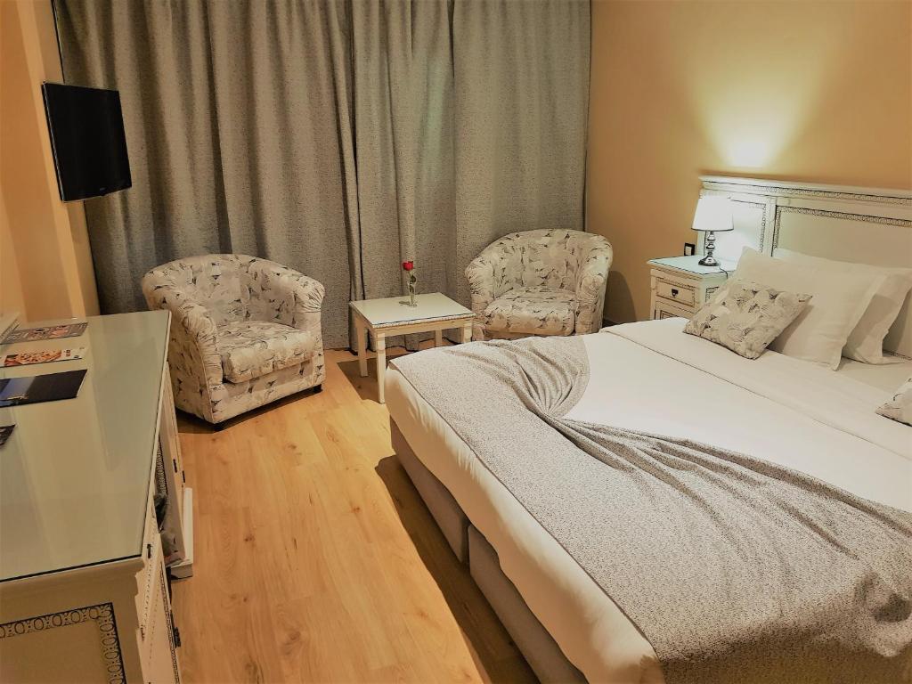 丹吉尔El Oumnia Puerto & Spa的酒店客房,配有一张床和两把椅子